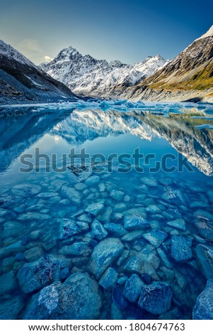 Hooker lake with snow capped Mount Cook in the distance reflecting in the lake and a beautiful clear blue sky Royalty-Free Stock Photo #1804674763