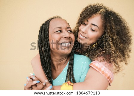 Happy african mother and daughter smiling and hug each other - Mother and adult child, family love