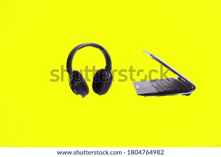 laptop and headphones isolated on yellow background