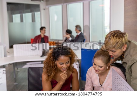 Young business workers from different ethnicities working closely to discuss a new plan in an office. Girls from diverse races have good relationship and enjoy working together for business project