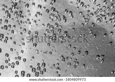 Closeup of air bubbles on the water surface, water boils in a steel tank, selective focus, top view, copy space