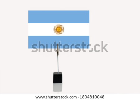 Argentinian Republic miniature flag in cube base in photograph holder on a white background