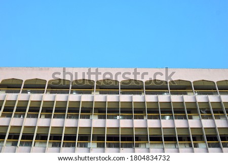 Tall building with a windows on a blue sky background. Selective focus image and minimalist concept. 