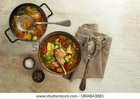 Serving healthy stew with rabbit meat and vegetables on grey background