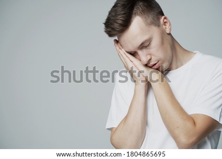 lazy male student is fast asleep, Vidlitsa rumpled sleepy. dream. white t-shirt and grey background. place a banner ad for a company