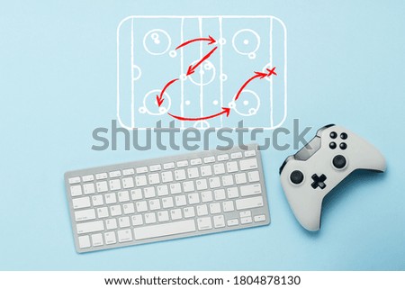 Keyboard and gamepad on a blue background. Doodle drawing with tactics of the game. Hockey. The concept of computer games, entertainment, gaming, leisure. Flat lay, top view.
