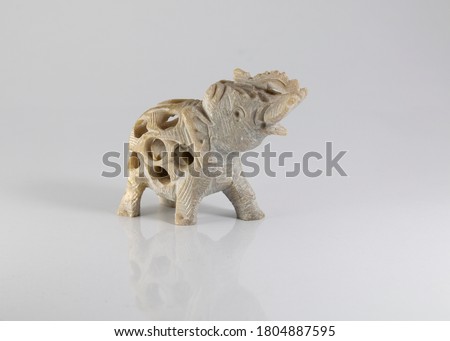 A handmade craft of white elephant with a baby in her womb. a travel souvenir from Goa India isolated on white background.