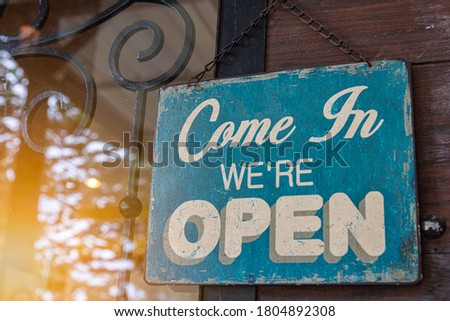 Come in we're open, vintage blue retro sign in cafe and restaurant front