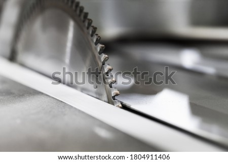 Circular table saw disc with carbide teeth, close-up photo with selective focus Royalty-Free Stock Photo #1804911406