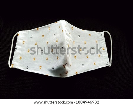 A cloth mask with double layered cotton and muslin can be put a filter sheet inside isolated on black background. A cloth mask for wearing to protect against viruses and the others when out in public.