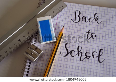 Back to school written on checkered notebook with pensil eraser and ruler