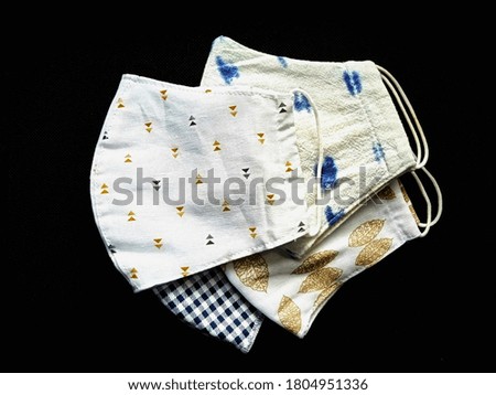 Top view image of the half folded cotton cloth masks isolated on black background. The washable cloth face masks for wearing to protect against viruses and the others when out in public, new normal.