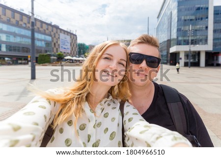 Capturing bright moments. Joyful young loving couple making selfie on camera. Pretty tourists make funny photos for travel blog
