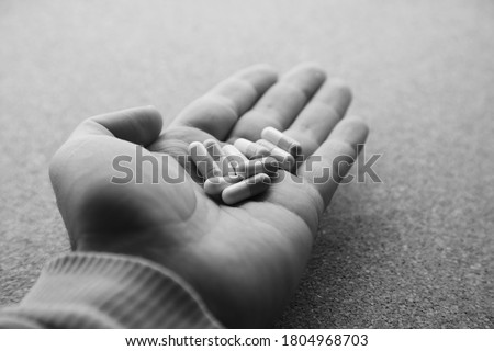 Hand holding opioid pills. Medical drug addiction concept photo. 