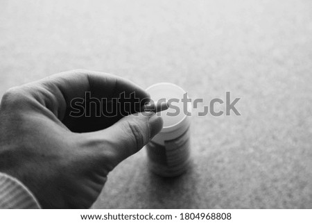 Hand holding an opioid pill. Medical drug addiction concept photo. 