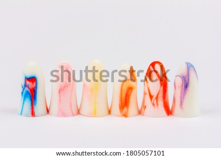 colorful foam earplugs on a white background close up