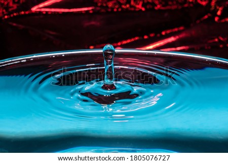 Water splash close-up. A frozen drop above the surface of the water. Drop of water. The frozen spray. Abstract background