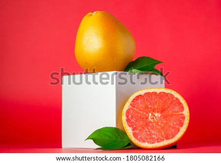 Citruses. Ripe, fresh, juicy grapefruits on a red background. Minimalistic composition.