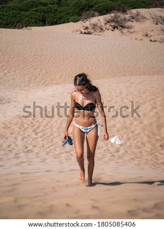 Girl walking on the desert in bikini with a fpp2 mask on her hand in Bolonia on August 2020