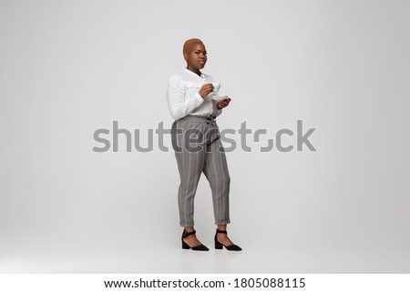 Young african-american woman in casual wear on gray background