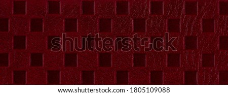 The surface of a  luxury leather product as a background, dark red, embossed. Top view, flat lay, place for text, copy space, wide view.