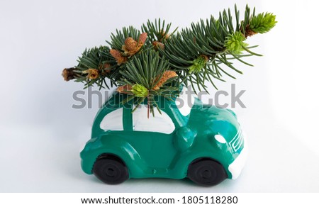 Green toy car-piggy Bank, carrying a Christmas tree on the roof