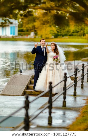 Newlyweds walk in the park and pose for a photographer