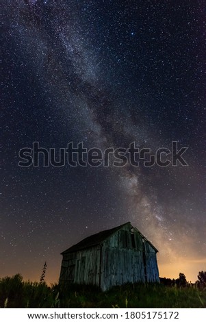 the milky way in the night sky above the abandoned barn