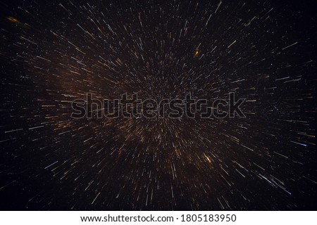 Meteor shower against the background of the black night sky and stars.