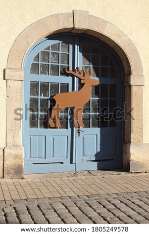 Reindeer sign hanging on large blue door in Rothenburg, Germany