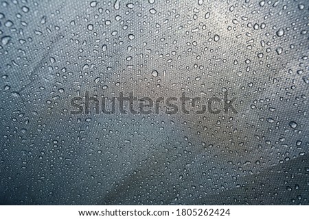 Close-up shot of water droplets on the tent. Macro photography. Camping in spring, summer and autumn. Background with space for text Royalty-Free Stock Photo #1805262424