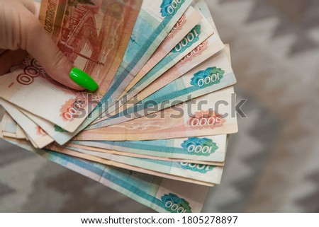 Сlose up of woman hand with bundle of money Russian Banknotes of one thousand and five tousand rubles. Business, finance, saving, banking and people concept