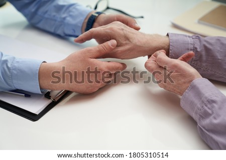 Top view of medical worker hands performing a rheumatological hand examination on an elderly patient Royalty-Free Stock Photo #1805310514