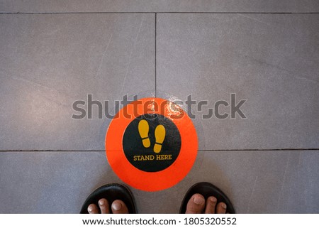 Stand here foot sign or symbol on the floor