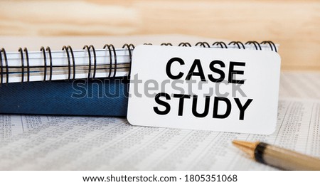 The inscription on the case STUDY business card, next to the pen and books.