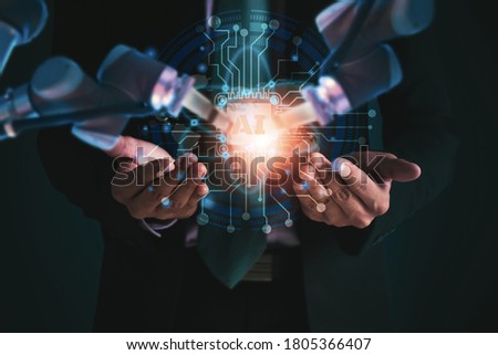 Businessman manager using interface screen display with monitoring working and control arm robotics via artificial Intelligence system,checking manufacturing operation robot arm in Industrial factory