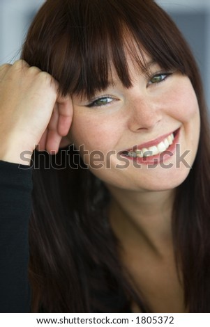 A beautiful young woman with green eyes laughing and happy