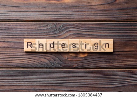 REDESIGN word made with wooden blocks concept.