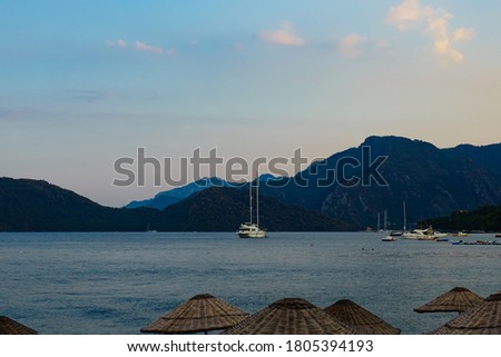 
the yacht sails on the sea with the mountains in the background