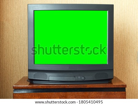 Vintage Television on wooden antique closet, old design in a home.Old black vintage TV with green screen to add new images to the screen.