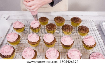 Frosting chocolate cupcakes with raspberry cream cheese buttercream.