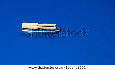 small wooden boat model on blue background