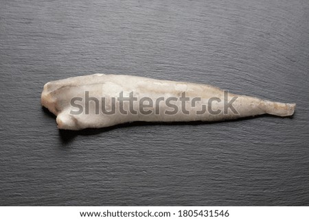 frozen hake fish on a black background. space for text
