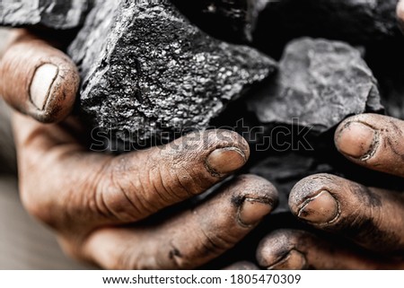 Miner dirty hands holding piece of fossil lignite coal mine. Royalty-Free Stock Photo #1805470309