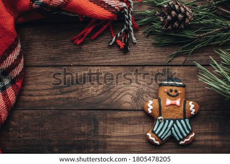 Christmas background with gingerbread cookies and fir branches on the old wooden board. 