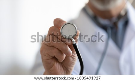 Close up mature doctor holding stethoscope, medical checkup, equipment, senior therapist practitioner gp ready to examine lings or heart sounds, healthcare and health insurance concept
