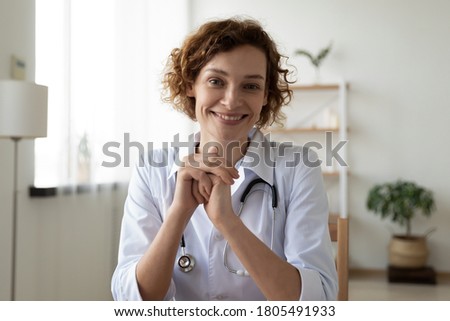 Head shot portrait smiling woman doctor wearing white uniform consulting patient online, friendly nurse physician gp looking at camera, blogger shooting video, telemedicine concept Royalty-Free Stock Photo #1805491933