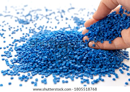 Blue plastic grain, plastic polymer granules,hand hold Polymer pellets, Raw materials for making water pipes, Plastics from petrochemicals and compound extrusion, resin from plant polyethylene. Royalty-Free Stock Photo #1805518768
