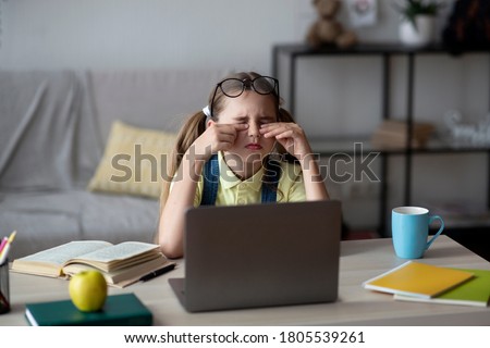 Eyes Fatigue. Tired little teenage girl feeling eyestrain, rubbing dry irritated eyes, sitting at desk with pc Royalty-Free Stock Photo #1805539261
