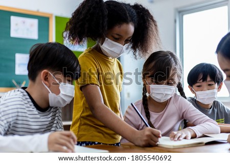 A group of Children students wearing medical masks in the classroom. An Asian woman teacher and students were discussing the lesson. Concept of prevention of the coronavirus outbreak And new normal Royalty-Free Stock Photo #1805540692